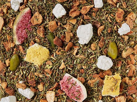 Groene Rooibos Thee Citroen Vijg met pistachenoten, vijgen en citroenschil – los in een houten lepel met exotische kruiden.