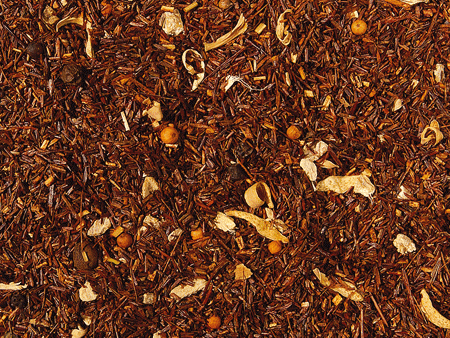 Losse Rooibos Ginger & Orange thee met sinaasappel, gemberstukjes en zonnebloemblaadjes in een kopje – cafeïnevrije kruidenthee.